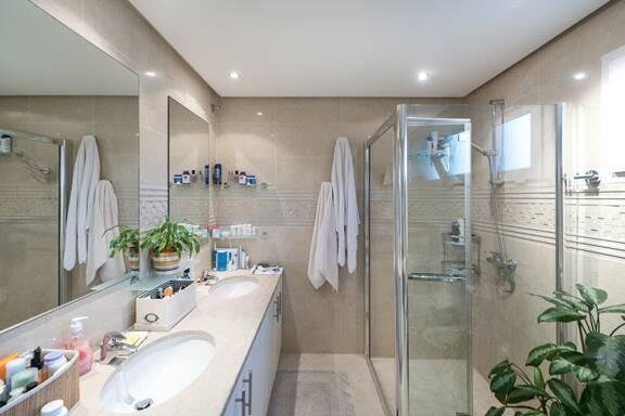 Family bathroom before renovation — original worn vanity and shower enclosure
